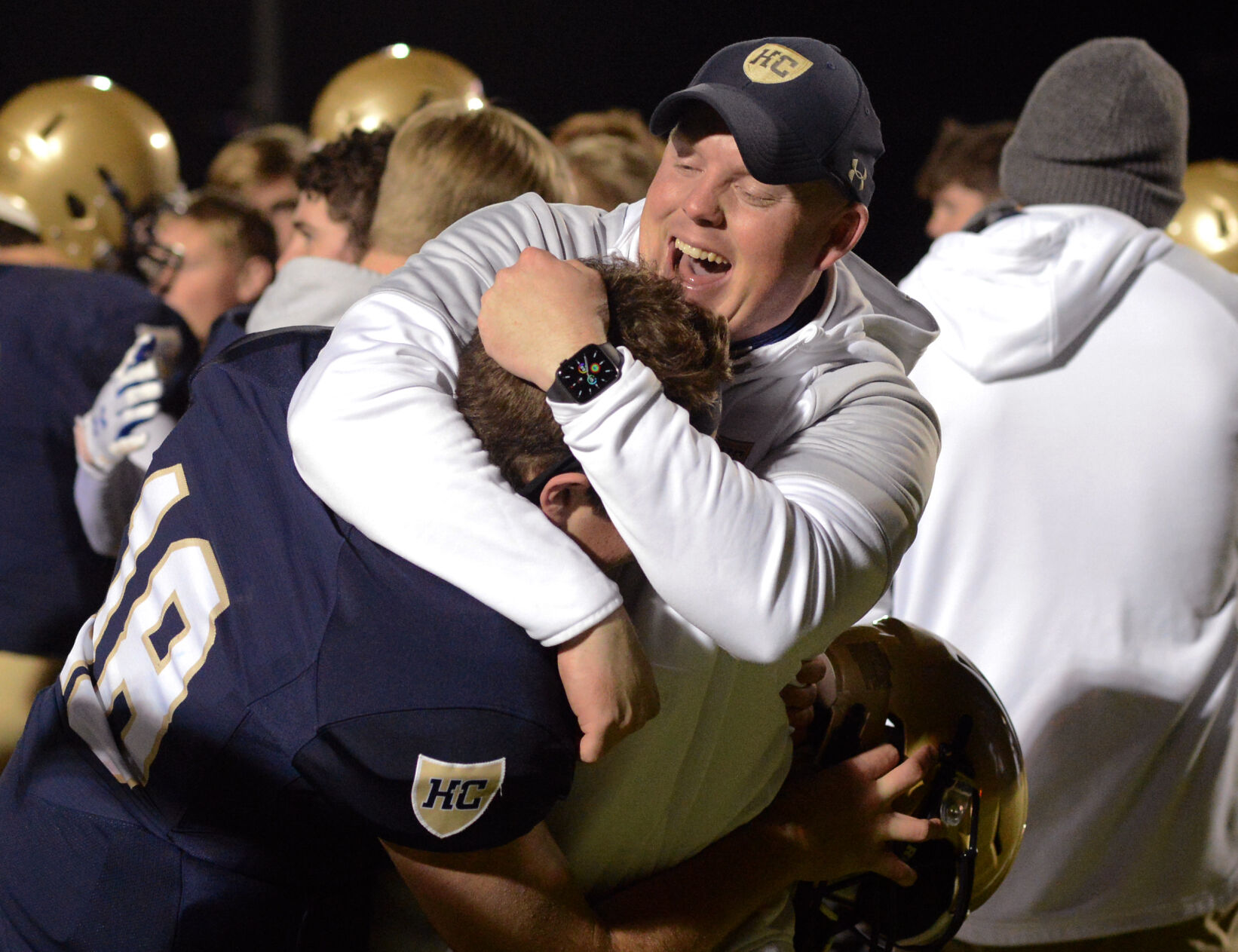 Helias assistant coach Garrett Wiggans embraces senior quarterback Zachary Wolken